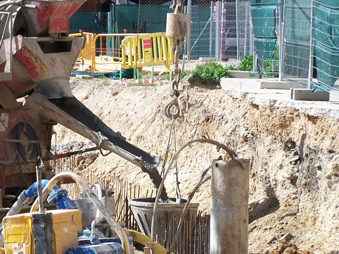 A concrete chute pouring into the tremie hopper above a diaphragm-wall panel