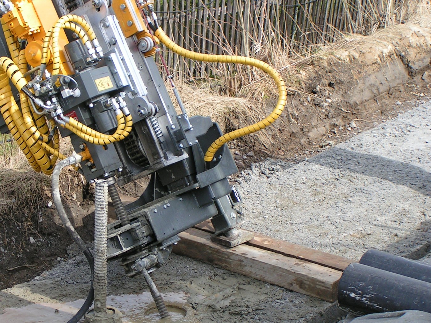 A drill head boring with cement suspension, the grey return standing at the borehole collar