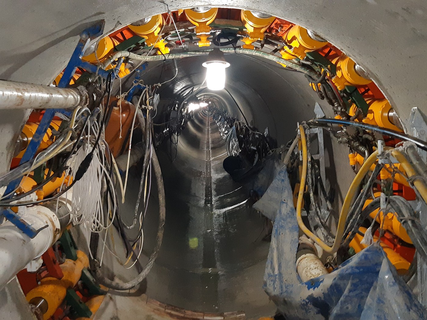 An intermediate jacking station inside a jacked pipe, looking back along the tunnel