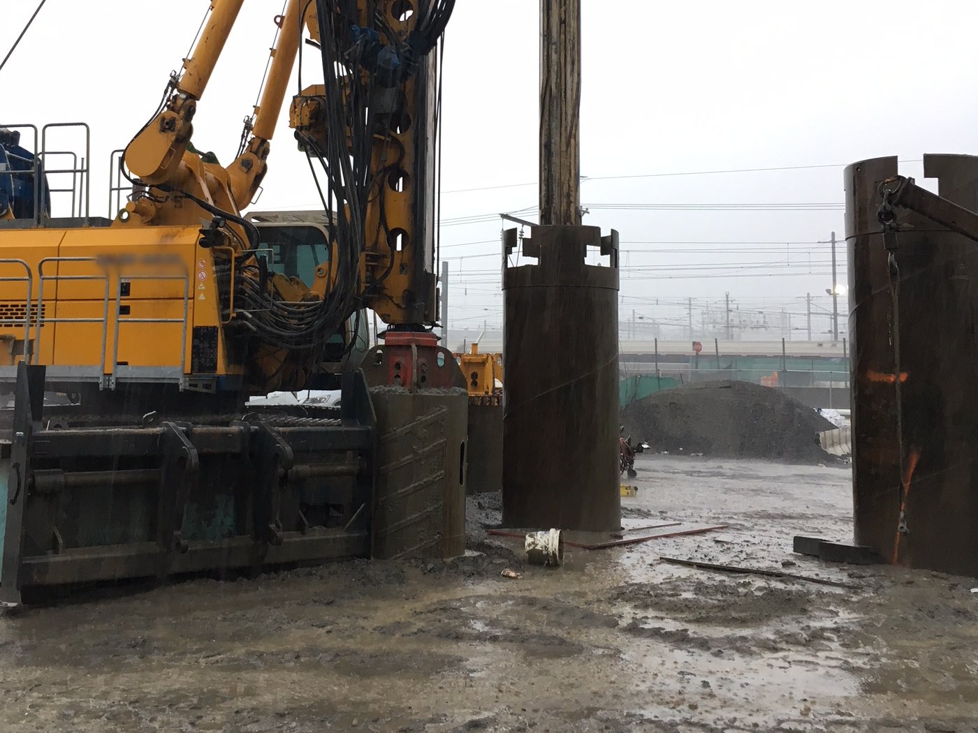 A piling rig drilling a bored pile through a steel casing