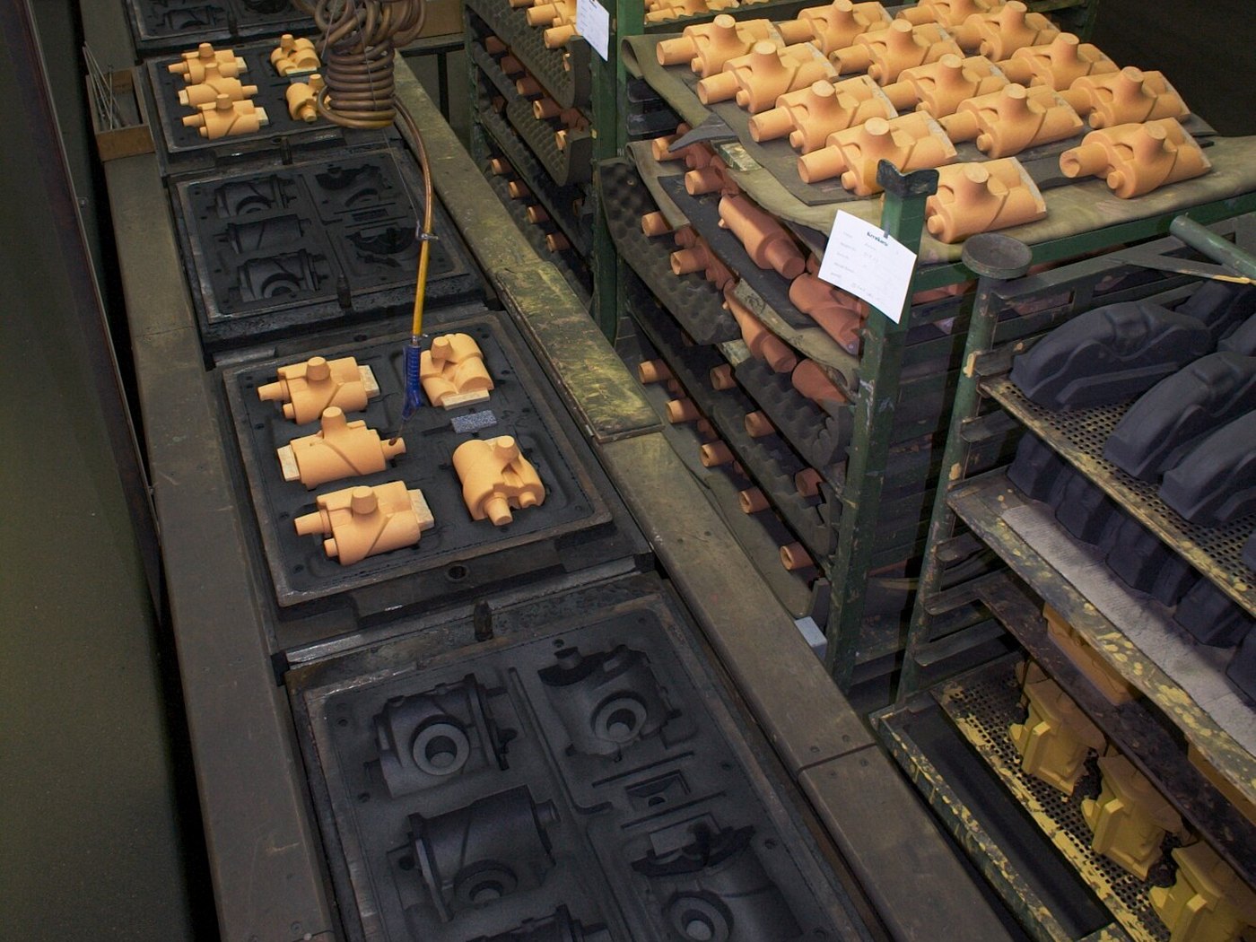 Sand moulds and moulded parts beside a machine moulding line in a foundry