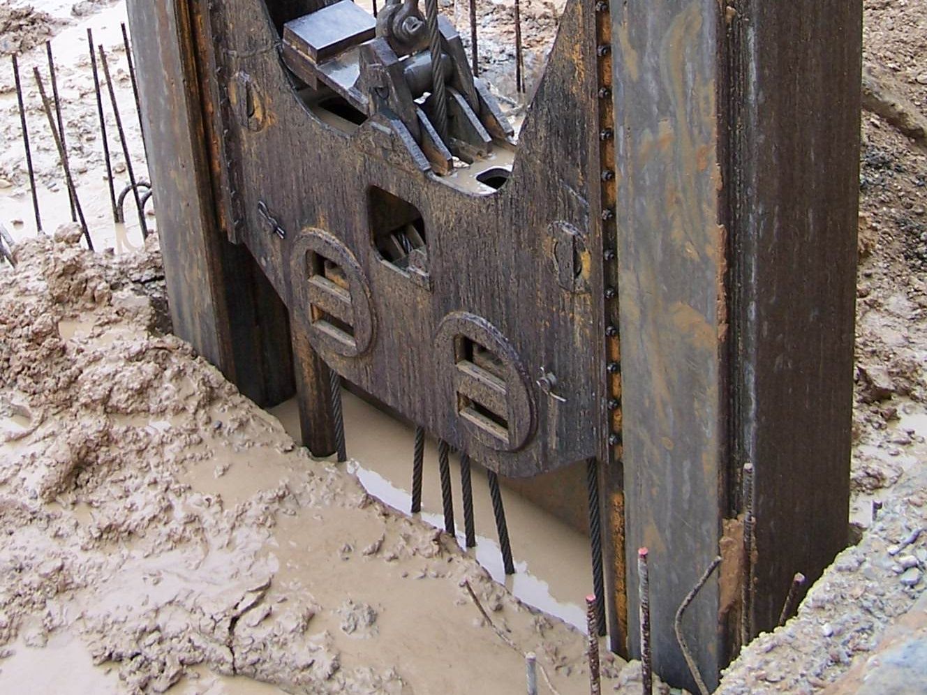 A diaphragm-wall grab above a panel full of bentonite slurry between guide walls