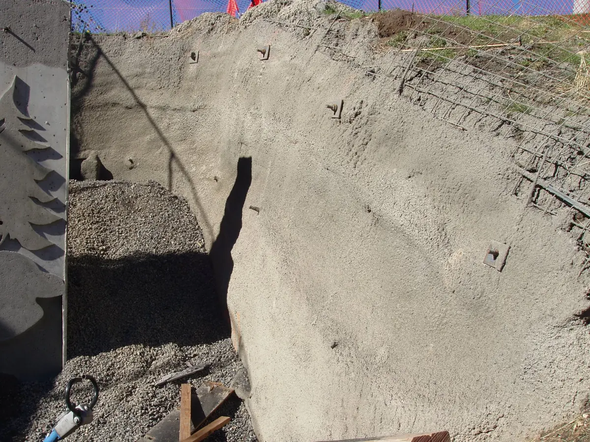 A soil-nailed, shotcreted embankment with the nail heads showing