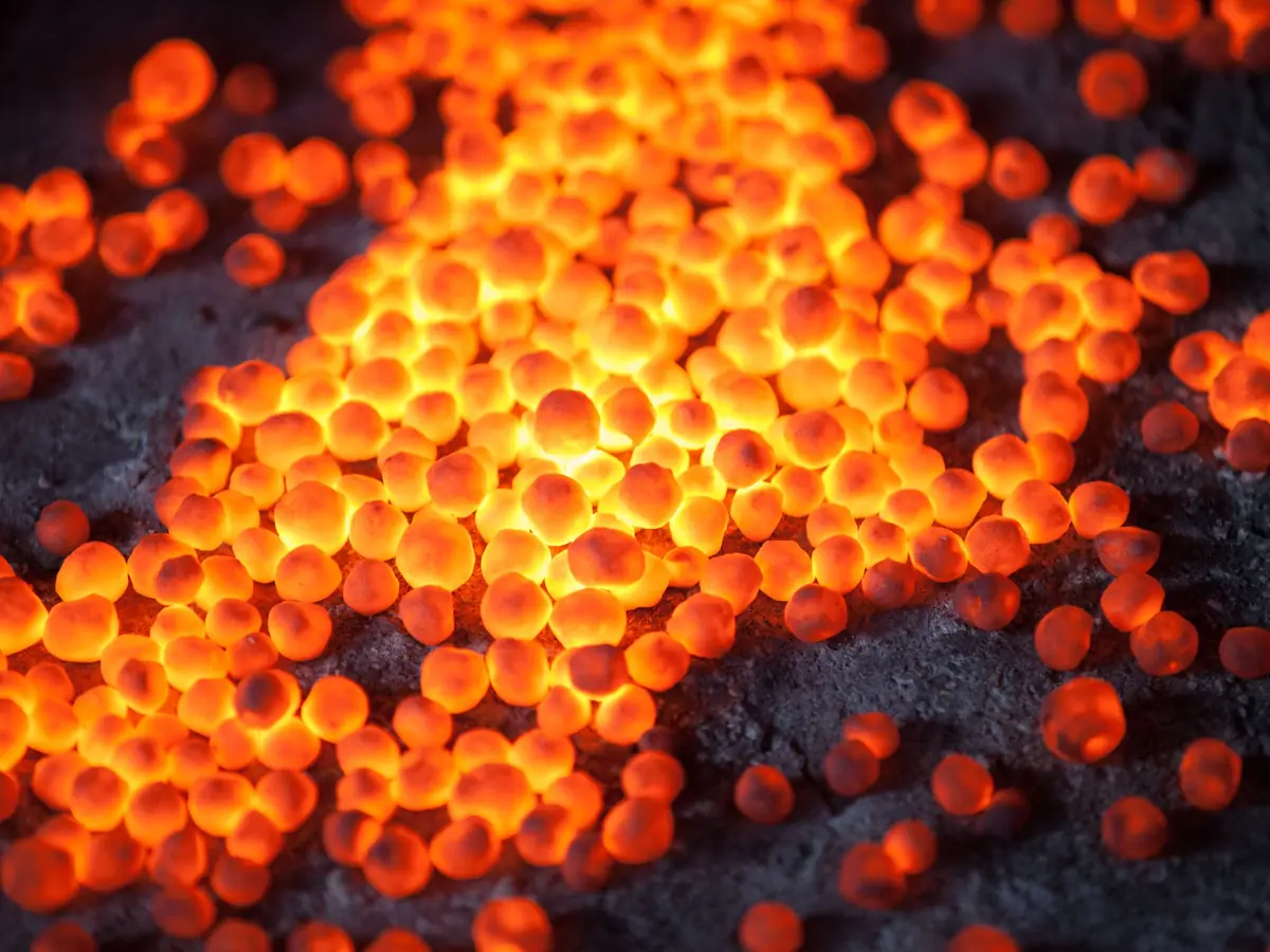 Fired iron ore pellets glowing at the end of induration